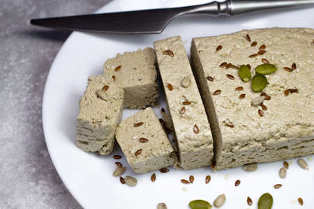 Halva close up on a white plate on a gray background. Traditional oriental dessert candy halva....