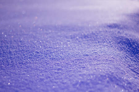 Trendy Color of the year 2022 Very Peri. Snowy white background. Texture of the snow. Shiny snow with bokeh and blurred background close-up. Lilac snow-covered field.の写真素材
