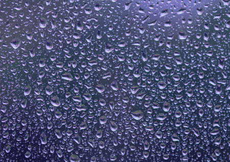 Trendy Color of the year 2022 Very Peri. Texture of rain drops on the glass close-up. Macro...