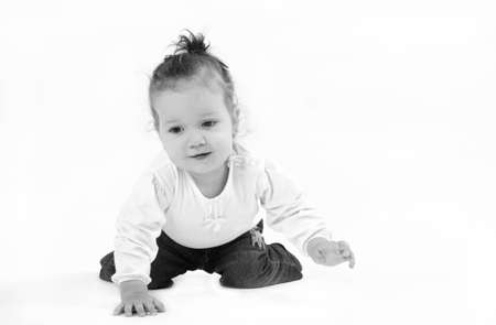 cute little girl crawling on his knees and looking thoughtfully into the groundの写真素材