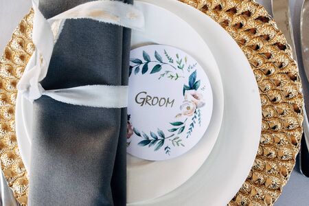 Decorated gold plate with green napkin with guestcard for groomの写真素材