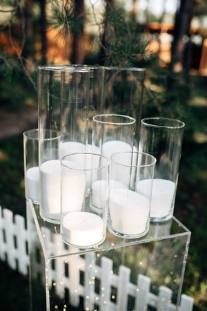 Decorated outdoor area with white wooden candle lamps and flowers on the grassの写真素材