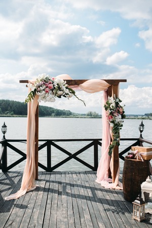wedding arch decorated with flowers on the river sideの写真素材