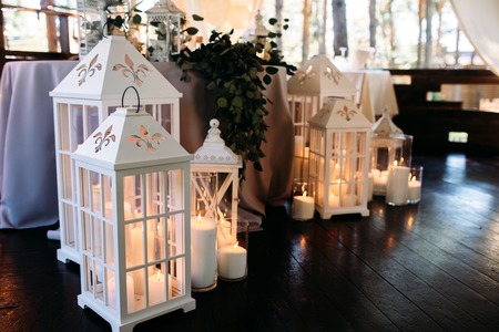 Decorated area with white wooden candle lamps and greensの写真素材