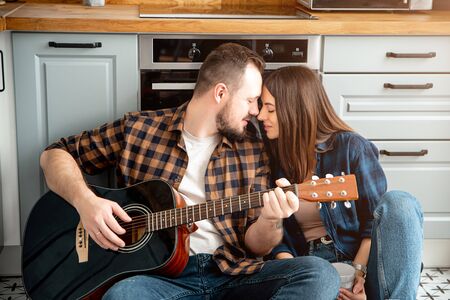 Close portrait of a couple in love. Guy with a guitar in his handsの写真素材