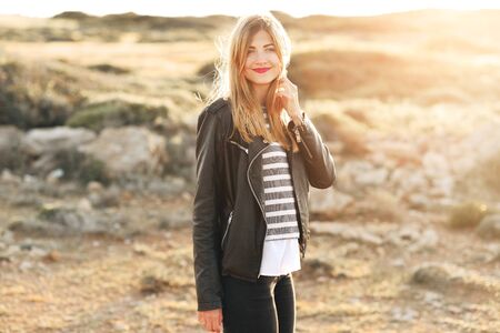 Happy beautiful girl with blonde hair laughing under sunlightsの写真素材