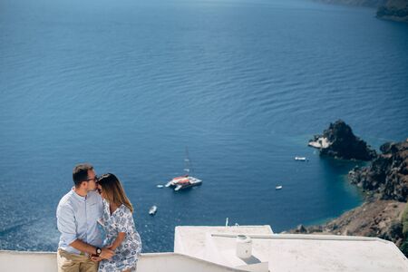 Happy couple are hugging and laughing together with amazing view on the sea. They are in summer casual wearの写真素材