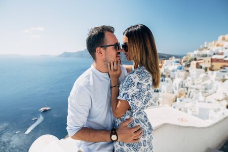 Happy couple hugging and laughing together with a view of Santoriniの写真素材