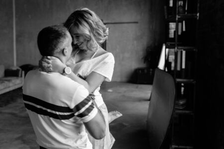 The photo is out of focus and with grain. The guy holds the girl in her arms in motion, she laughs.の写真素材