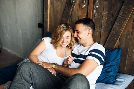 Happy couple in home clothes laughing in bed