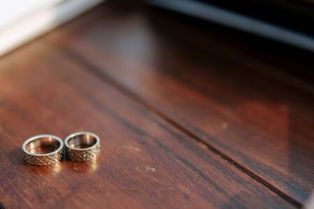 Wedding rings on a wooden background in daylight