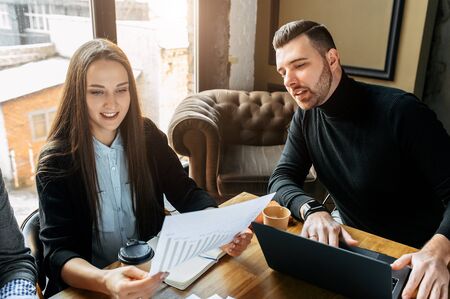 Successful business team. Young Timlid explains some documents to a girl employeeの写真素材