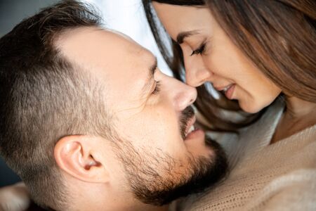 Love story. A close photo of the face of a guy and a girl, they look into each other's eyesの写真素材