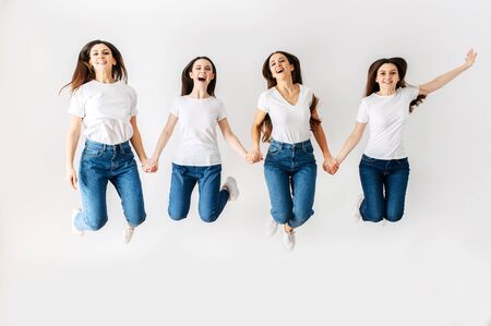 female power. A group of young beautiful girls in the studio are jumping high. Isolated photoの写真素材