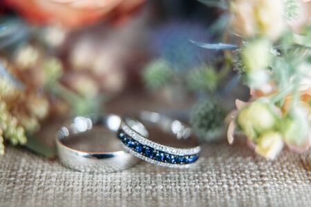 The main details of the wedding day. White gold wedding rings close up, a wedding bouquet in the...
