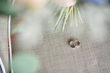 The main details of the wedding day. White gold wedding rings on linen fabric