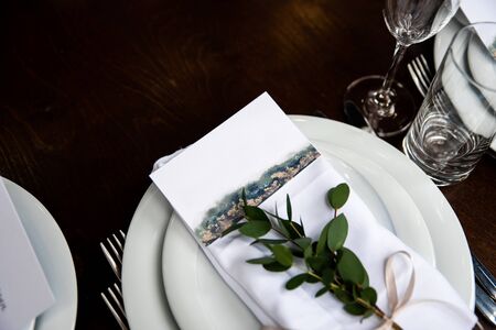 Guest card on the white napkin with branch of eucalyptusの写真素材