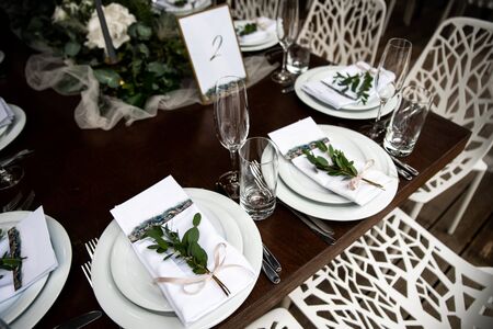 Classic white plates with guest cards and eucalyptus on themの写真素材