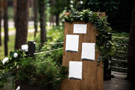 Wooden board with blanks for seating guests decorated with green branches