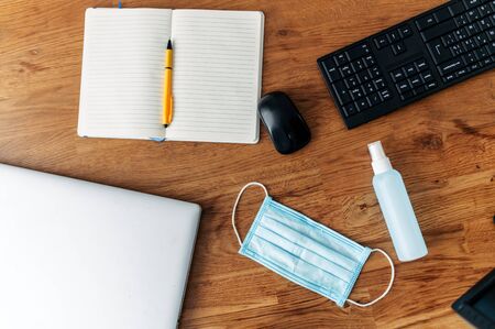 Precautions to avoid the spread of viral diseases, covid 19. Mask and sanitizer on the desktop, near...