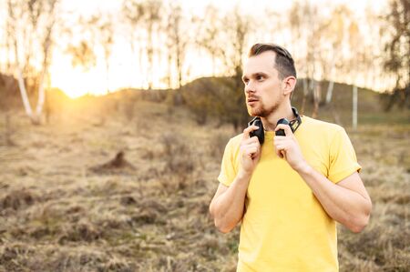 Sports lifestyle. Bearded handsome guy with headphones going to do outdoors workoutの写真素材