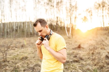 Sports lifestyle. Bearded handsome guy with headphones going to do outdoors workoutの写真素材