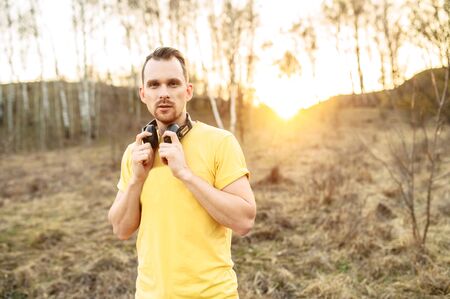 Sports lifestyle. Bearded handsome guy with headphones going to do outdoors workoutの写真素材