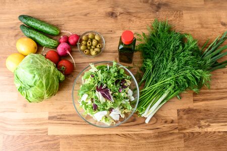 Flat lay of fresh vegetables and greens on the table for cooking salad. Healthy food concept. Cooking at homeの写真素材