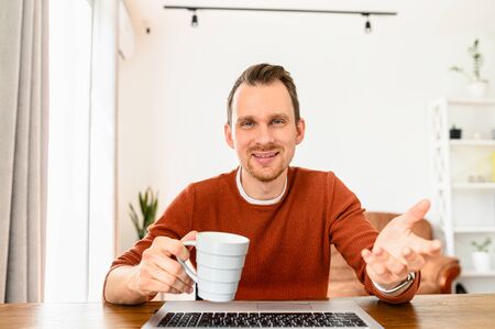 Online conversation with friend. Webcam view of attractive young man, he is smiling and looks at camera. Video chat, video call, zoomの写真素材