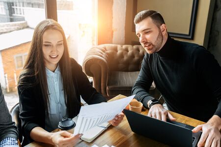 Successful business team. Young Timlid explains some documents to a girl employeeの写真素材