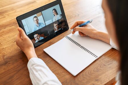 Webinars, online conference, video meeting. Young woman using app on tablet for video connect with a...