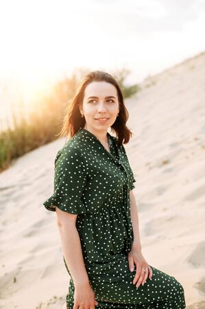 Natural beauty. A young attractive woman in a casual green dress outdoors. Walk in natureの写真素材