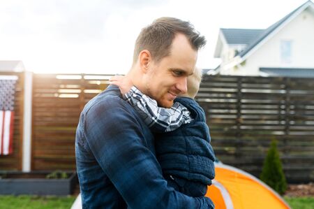 Father and son spend time together in the backyard. Cute baby boy hugs daddyの写真素材