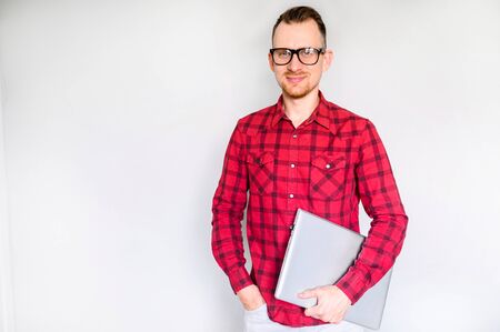 Hipster in eyeglasses with laptop isolated on gray background indoor. Studio shotの写真素材