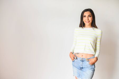 Gorgeous girl with a long well-groomed hair in short jeans skirt, isolated on white backgroundの写真素材