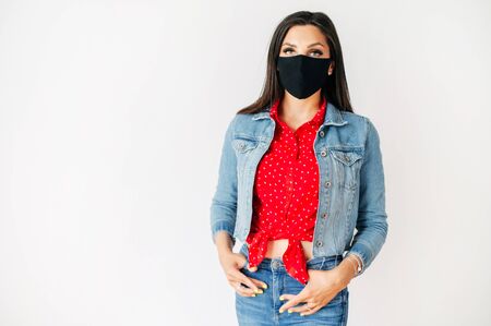 Be in safety. Young woman protect herself with a black mask on the face. Studio shot on white backgroundの写真素材