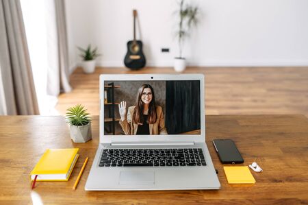 Video call. Webcam shot young woman on the laptop screen indoor in empty roomの写真素材
