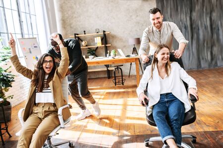 Fun corporate games of young multiracial team in cosy office. A friendly informal atmosphere of young team in the officeの写真素材