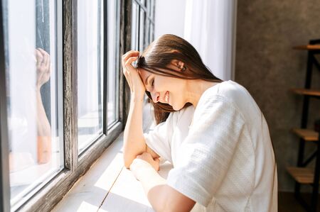 Photo indoor of cheerful young long-haired woman in white t-shirt in relaxed pose laughsの写真素材