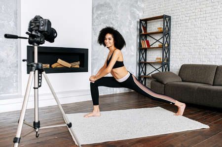 Young sporty slim mixed-race woman yoga coach records video online training yoga. Healthy lifestyle concept, video tutorial conceptの写真素材