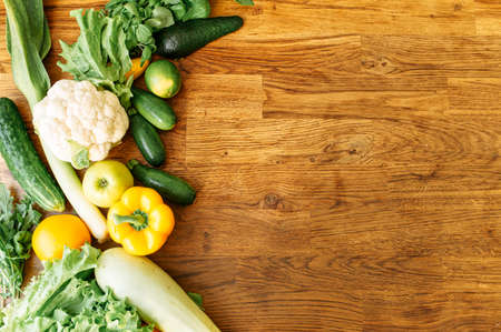 Various fresh vegetables are laid out on the table, on the edge of the frame. Vegetarian food concept. Copy Space, mockupの写真素材