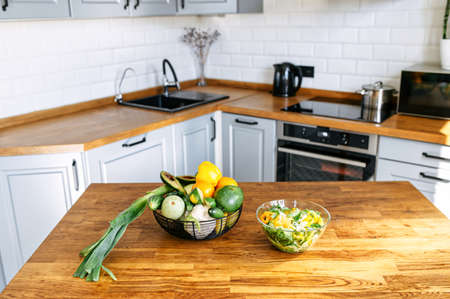 Cook at home easy. A tasty and healthy lunch from veggie ingredients on the table, basket with farm vegetables nearの写真素材