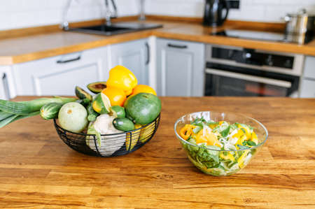 A tasty and healthy lunch from veggie ingredients. A bowl of salad and basket with farm vegetables...