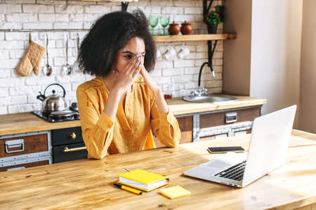 Unhappy mixed-race woman freelancer has a deadline with a remote work. Tired woman does not have...