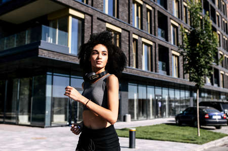 Jogging in the city. Young attractive athletic African-American woman in sportswear running outdoors. Healthy lifestyleの写真素材