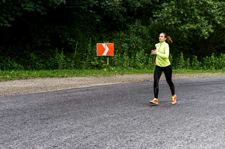 Full length shot of a slender athletic woman running outdoors. Healthy lifestyle conceptの写真素材