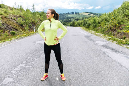 Healthy young woman rest after sprint outdoors. Running in the mountainsの写真素材