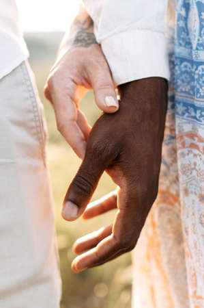 Multiethnic love. Black and white hands holding each other, close up pictureの写真素材