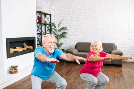 Sport and healthy lifestyle concept. Senior couple warming up before workout at homeの写真素材