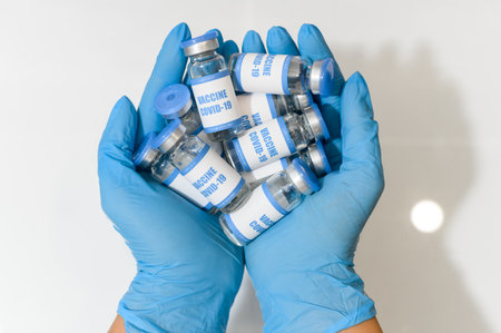 Hands of a medic in gloves holds a vaccinesの写真素材